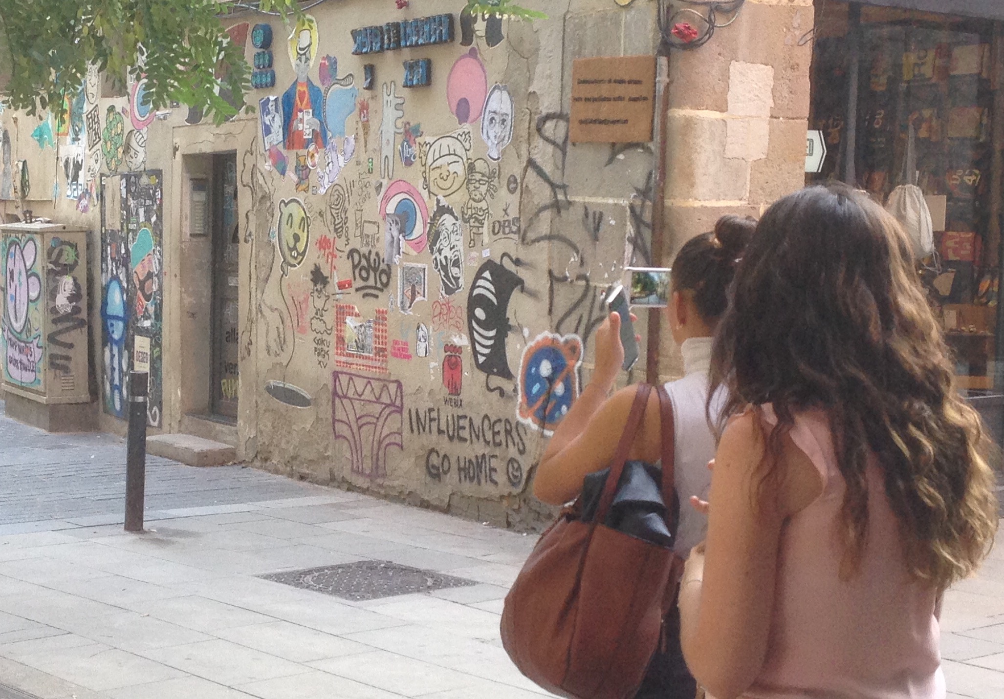 Una turista fotografia el mur d'Allada Vermell.