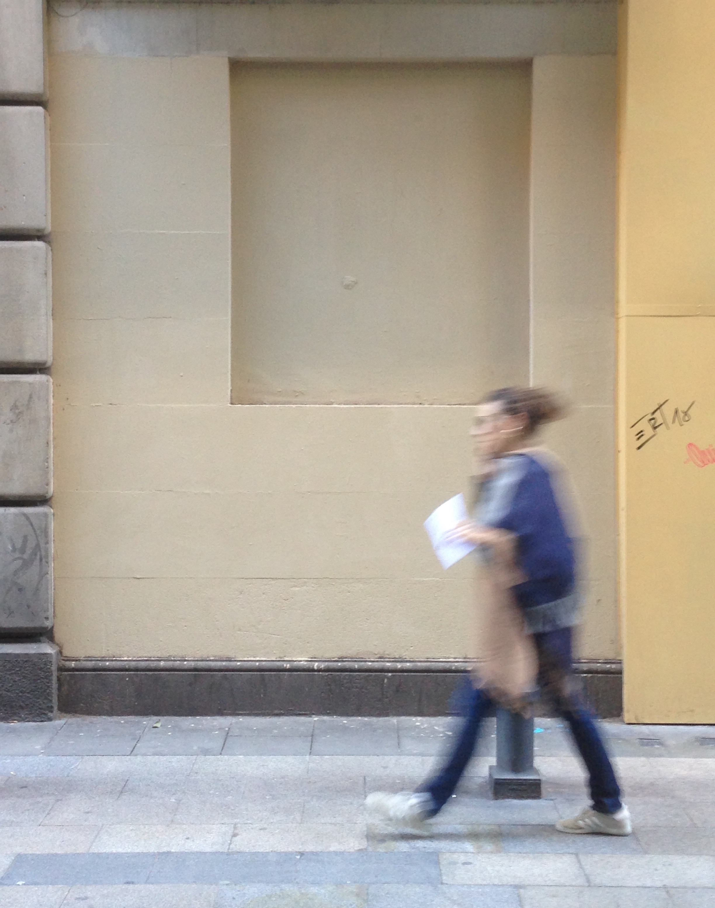Un chica camina junto a la pared, donde ha desaparecido el rastro del duelo.